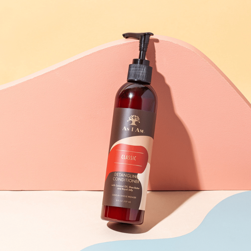 Auf pastellfarbenem Hintergrund steht eine braune Flasche mit schwarzer Pumpe. Die Flasche enthält As I Am Classic Detangling Conditioner und hat ein braunes Etikett mit gelber Aufschrift.