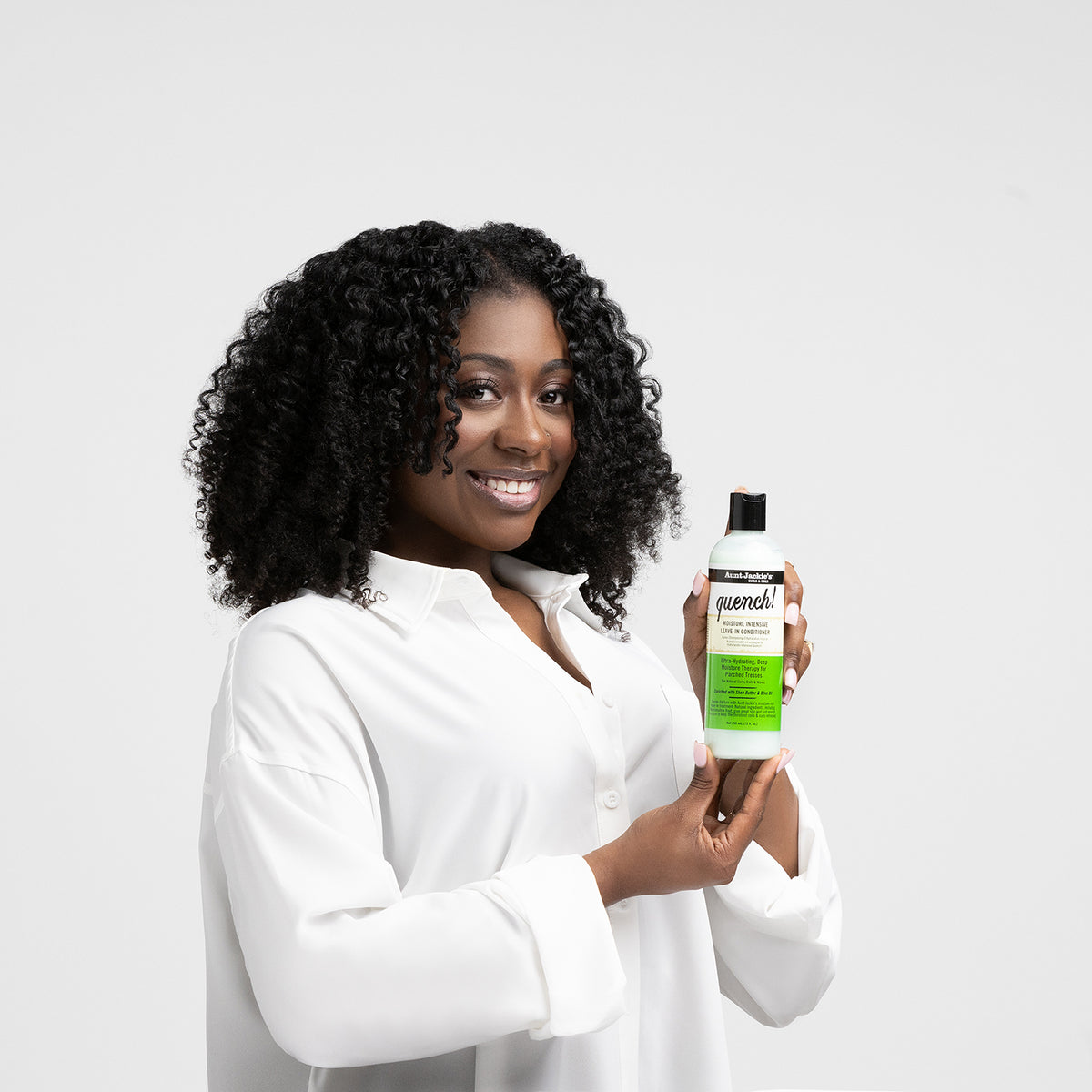 Clutch mit einer hellgrünen Flasche Aunt Jackie's Quench Moisture Intensive Leave-In Conditioner mit schwarzem Verschluss.