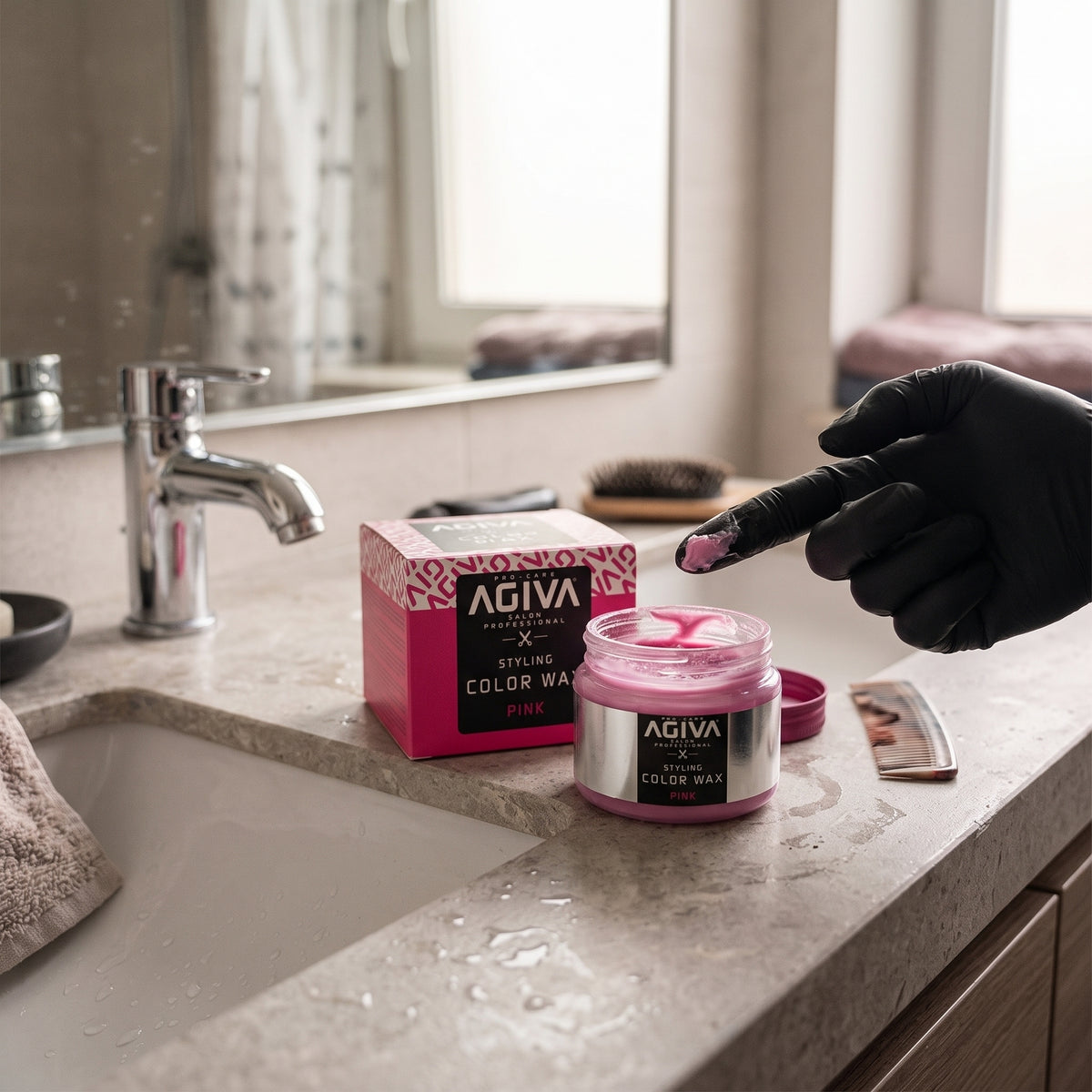 AGIVA Color Wax Rosa Haarwachs in geöffnetem Glas auf dem Badezimmertisch, Hand mit schwarzem Handschuh nimmt Wachs auf den Finger.