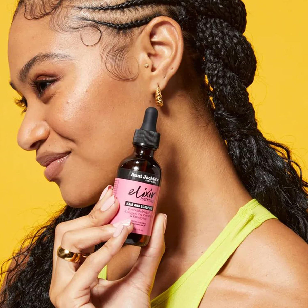 Frauen halten eine Flasche Tante Jackie's Elixir Hair and Scalp Oil in der Hand.