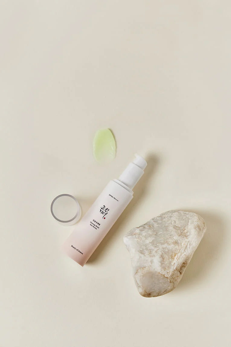 Flasche Beauty of Joseon Ginseng Moist Sun Serum 50 ml auf beigem Hintergrund mit heller Stein- und grüner Gelstruktur.