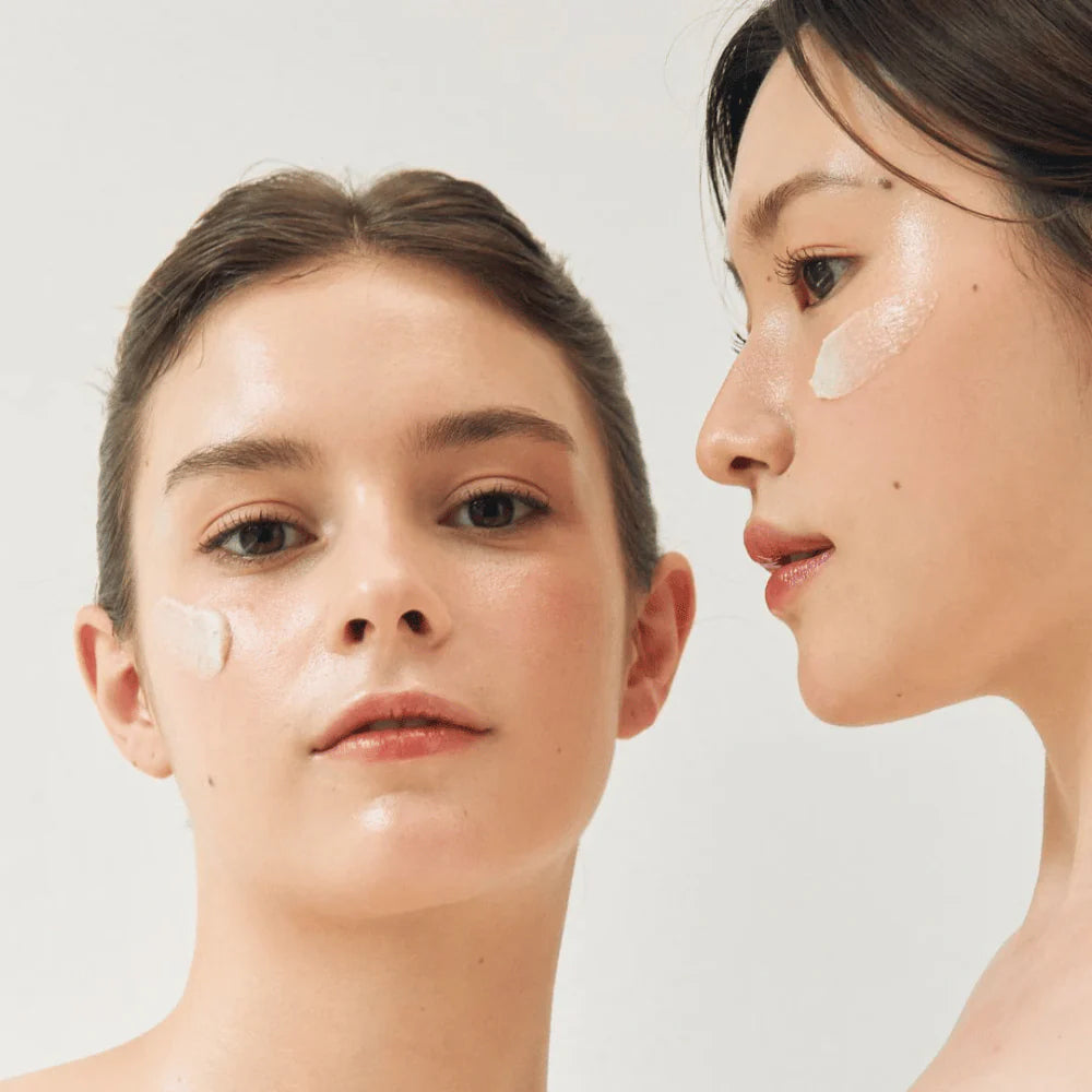 Zwei Frauen mit strahlender Haut und aufgetragener Beauty of Joseon Ground Rice and Honey Glow Mask 150 ml in einer hellen und sauberen Umgebung.