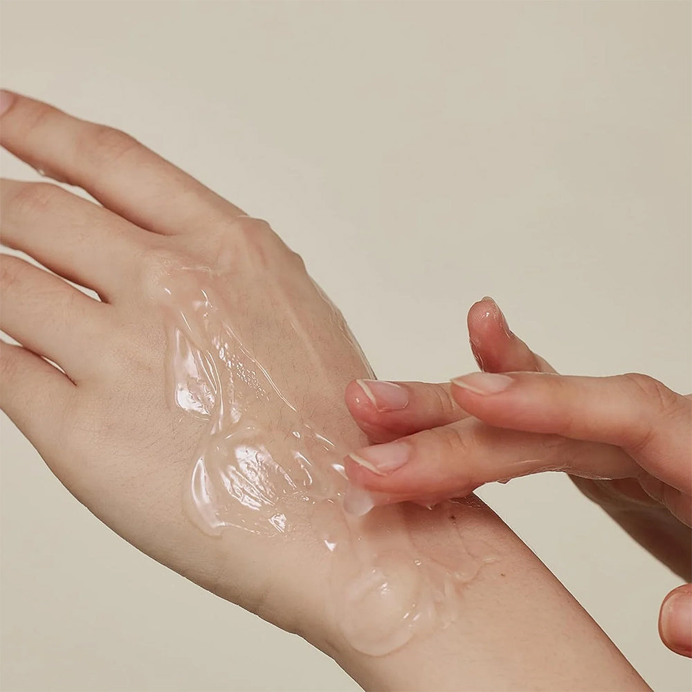 Die transparente Geltextur von Beauty of Joseon Red Bean Water Gel 100 ml wird mit den Fingerspitzen auf die Haut der Hand aufgetragen.
