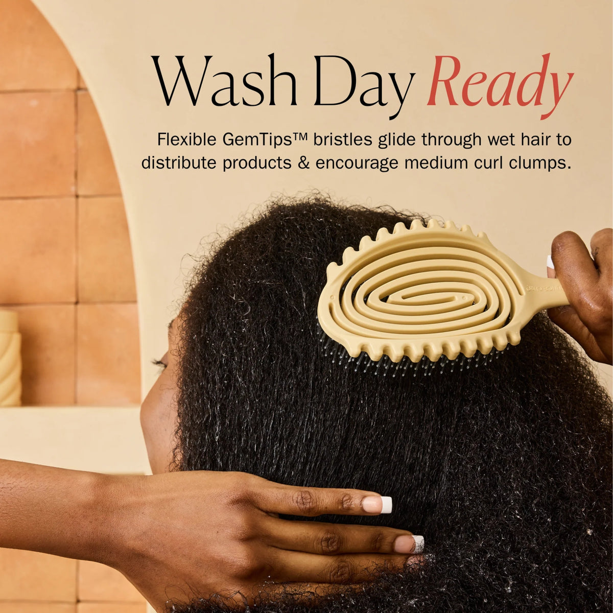 Die gelbe Spiralhaarbürste mit GemTips-Borsten bürstet sich während der täglichen Waschroutine durch nasses Afro-Haar.