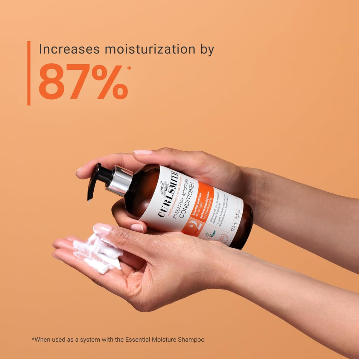 Curlsmith Essential Moisture Conditioner in der Hand mit Creme erhöht die Feuchtigkeit im Haar um 87 %.