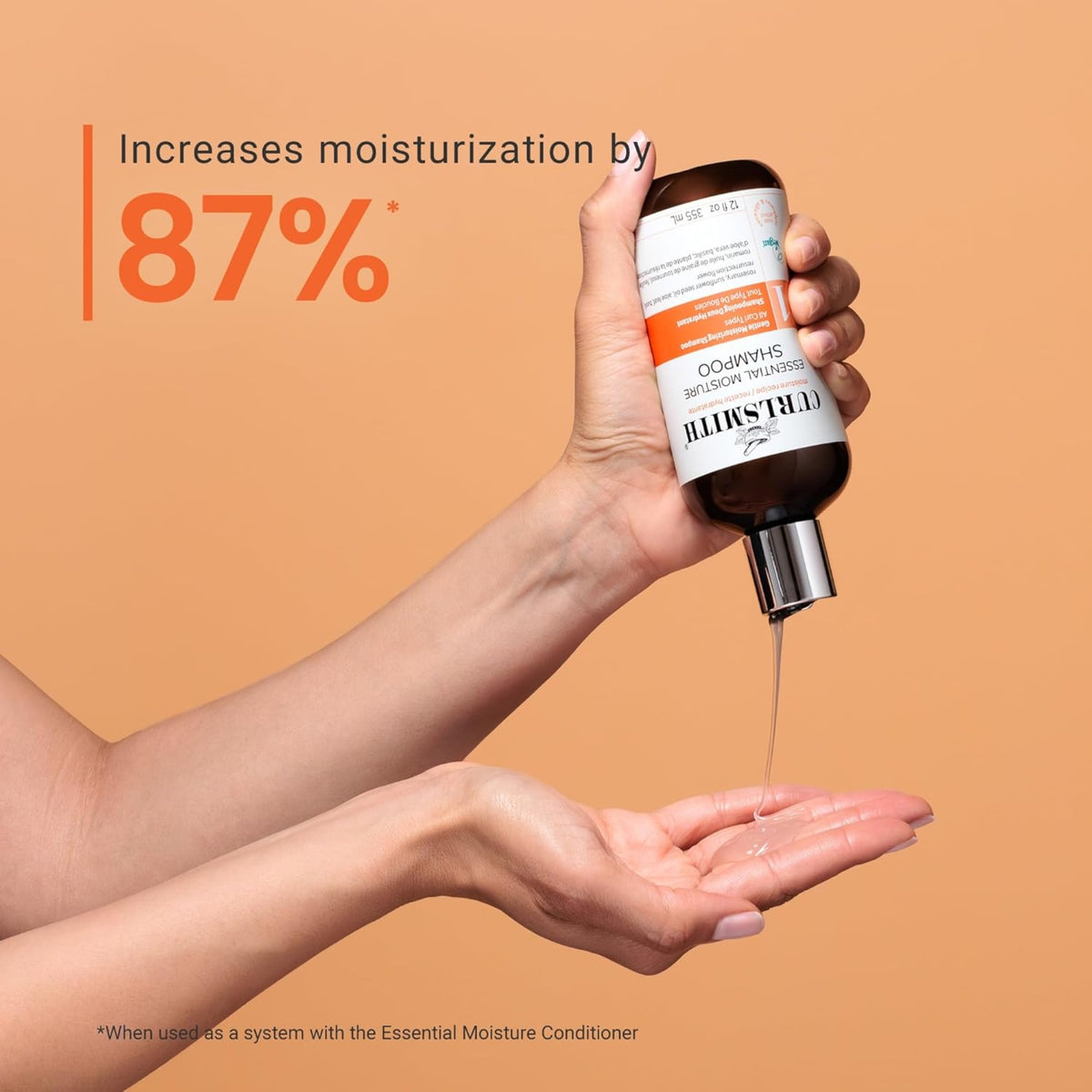 Curlsmith Essential Moisture Shampoo wird in die Hand gegossen, der Text zeigt eine um 87 % erhöhte Feuchtigkeit im Haar.