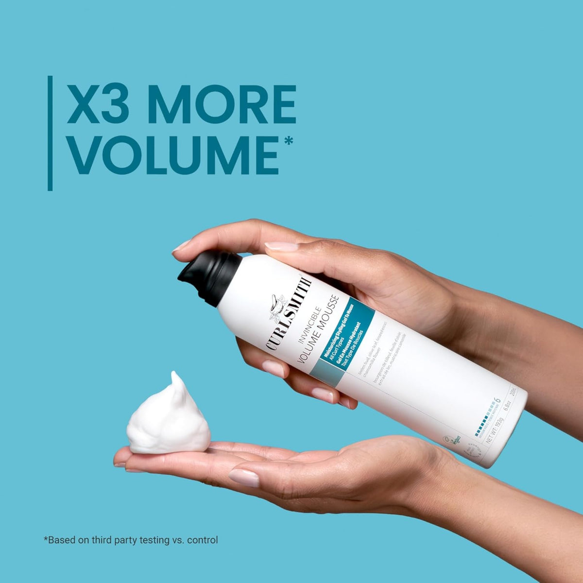 Die Hand hält Curlsmith Invincible Volume Mousse und drückt weißen Schaum in die andere Hand, Text „X3 More Volume“.