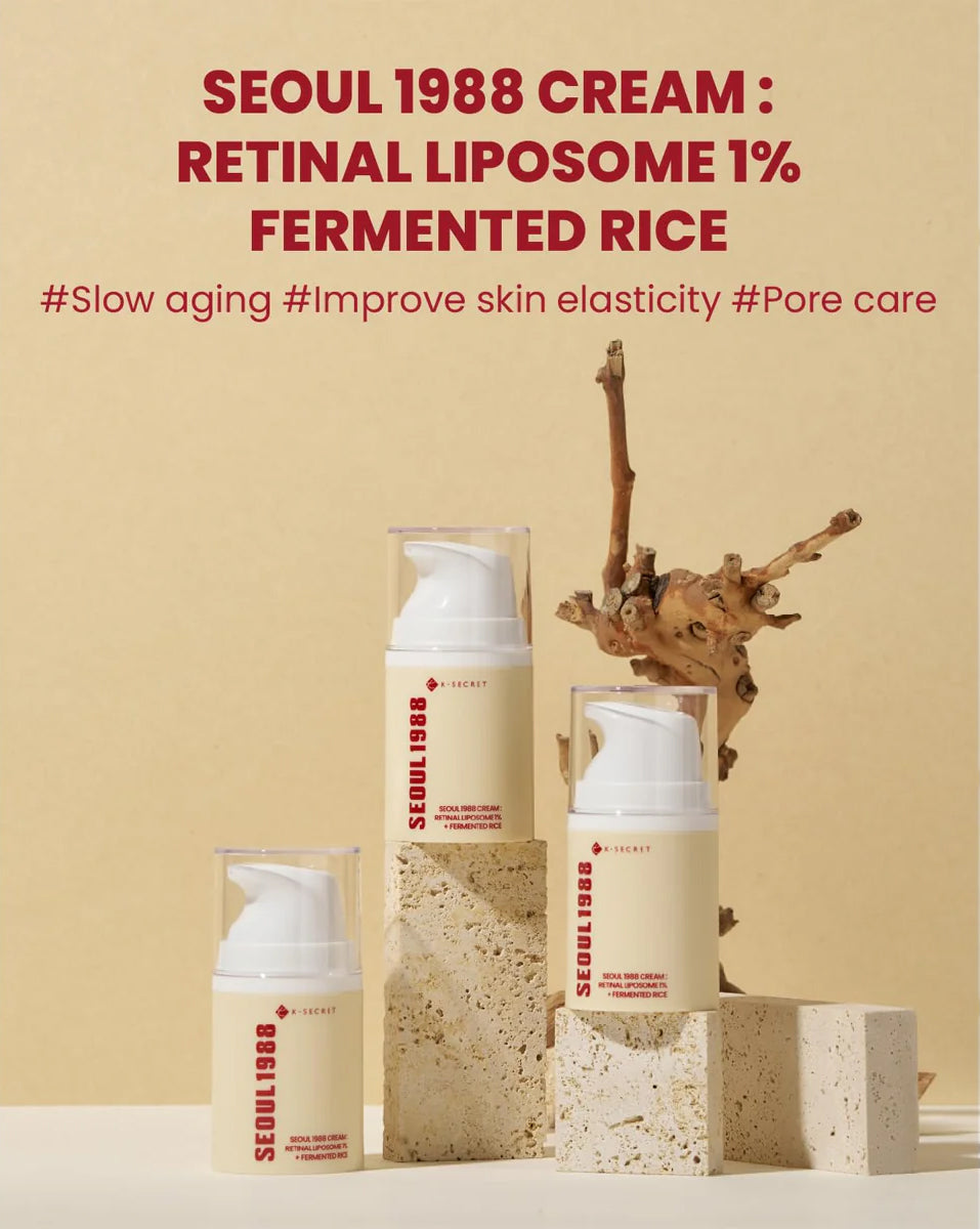 Drei Flaschen K-Secret Cream: Retinal Liposome 1% + Fermented Rice 50 ml stehen auf hellen Steinen vor beigem Hintergrund.