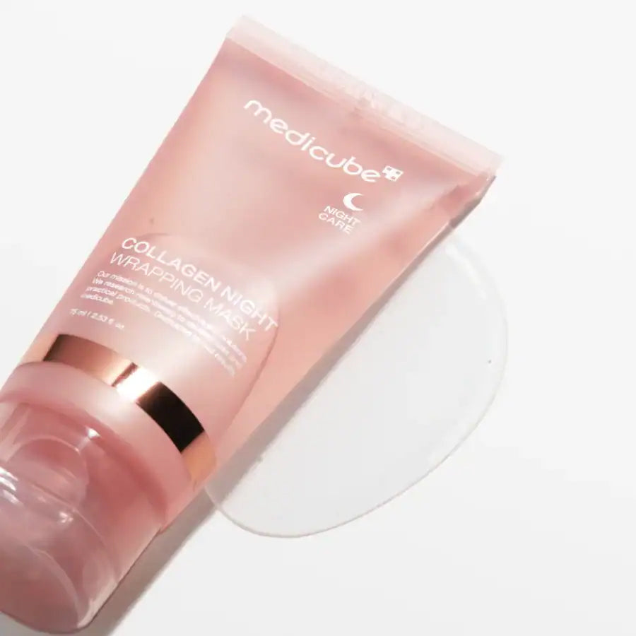 Medicube Collagen Night Wrapping Mask 75 ml in rosa Tube liegt auf einem weißen Hintergrund mit etwas Gel um die Öffnung.