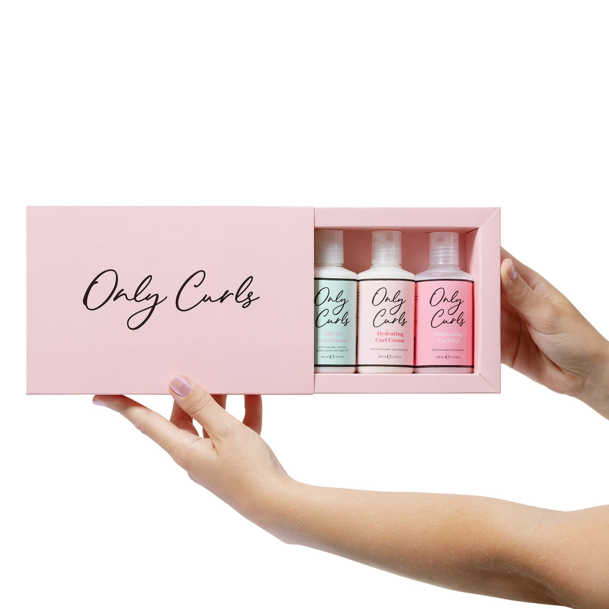 Hænder holder åben lyserosa Only Curls gaveboks med tre hårplejeprodukter: conditioner, curl creme og curl gel.