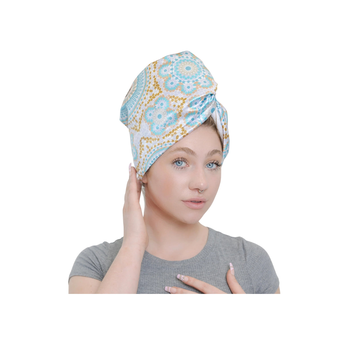 Frau trägt Bounce Curl Satin-Mikrofaser-Turban mit buntem Blumenmuster in den Farben Blau, Weiß und Gold.