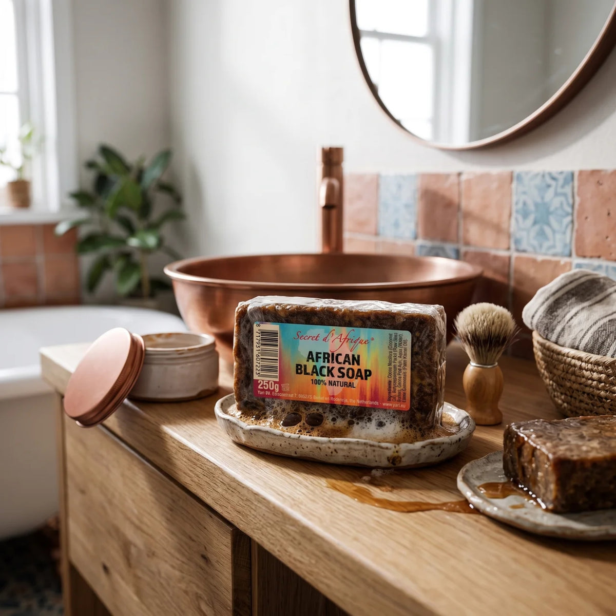 Secret d'Afrique African Black Soap 250g auf Keramikseifenschale am Kupferwaschbecken im Badezimmer.