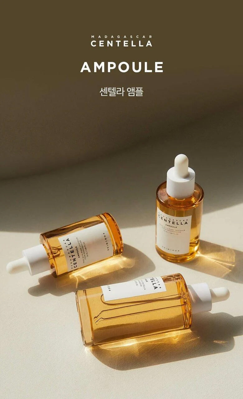 Drei Flaschen SKIN1004 Madagascar Centella Ampoule 55 ml mit goldenem Serum auf einer hellen Oberfläche im Sonnenlicht.